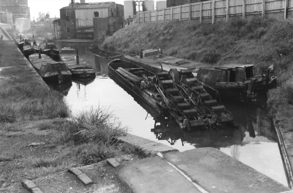 image B.C.N. Titford Branch. A selction of Thos. Clayton's tar boats and the bucket ladder dredger constructed by J. Matty parked below the bottom lock. Roving bridge over Old Main Line can be seen in the L.H. corner opposite entrance to Springfield Works 1958.
