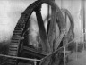 image Claverton Pumping Station, Kennet & Avon Canal. Pit wheel - showing damaged wooden teeth also flywheel, follower, crankshaft, coupling to water shaft & part of fluted connecting rods. 1954.
